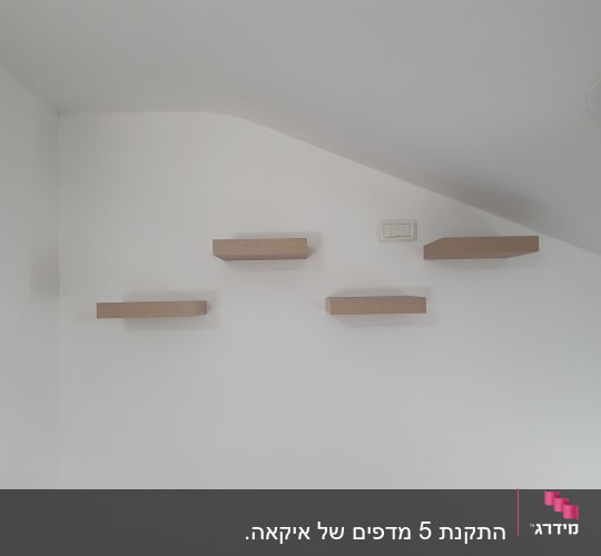 מדפים מעץ מותקנים על קיר לבן